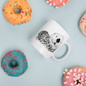 Pen & Ink Sea Otter Head mug seen from above among colorful sprinkled donuts