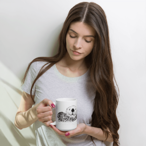 Person in a white sweater holding the Pen & Ink Sea Otter Head mug