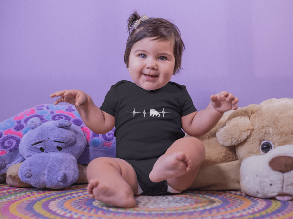 Otter Heartbeat Onesie on baby with stuffed animals Mockup in Black.