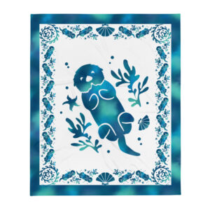 Sea Otter Tie-Dye throw blanket laid flat: a blue tie-dye otter floating among kelp, shell border