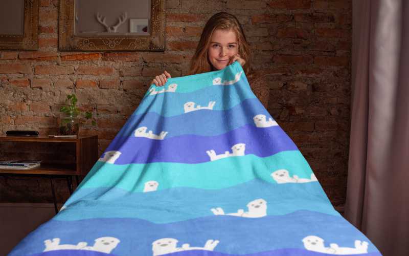 woman with wavy striped throw blanket with otters on it