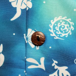 Close-up of a coconut-style button on the Sea Otter Tie-Dye Hawaiian shirt's print