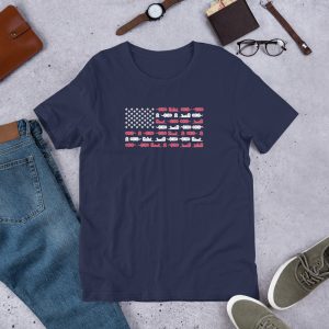 The Sea Otter USA Flag Unisex T-shirt in navy blue is displayed with jeans, green sneakers, a brown watch, glasses, a wallet, and a brown pouch on a gray surface.