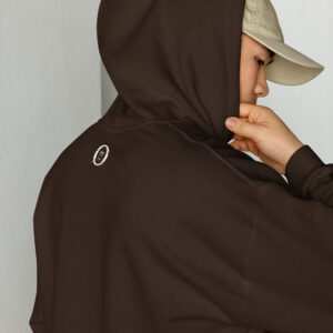 Unisex-heavy-blend-hoodie-dark-chocolate-back-6abac5d643ee8 | Otter Things Person wearing a brown hoodie with a small white smiley face on the back and a beige cap, facing sideways and pulling the hoodie’s hood closer to their face.